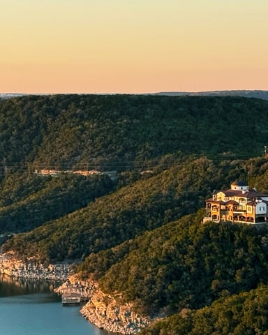 Rolling Hill Country hills at golden hour with a house on the ridge