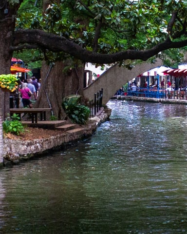 San Antonio River Walk with stone bridge and boats
