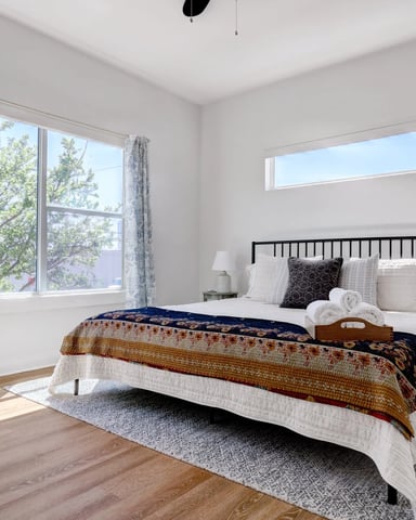 Urban townhouse bedroom with tree views through large window