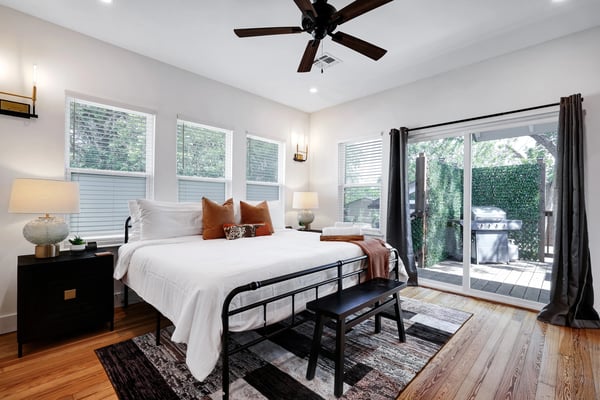 Longhorn bedroom with king bed, warm lighting, and sliding door to private deck