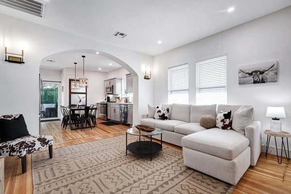 Longhorn living room with sectional sofa, fireplace, and open kitchen beyond